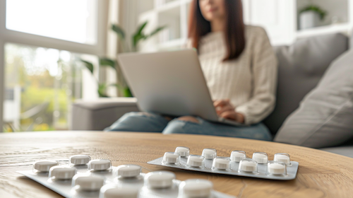 Frau sitzt auf der Couch und bestellt Medikamente bei vitenda.de
